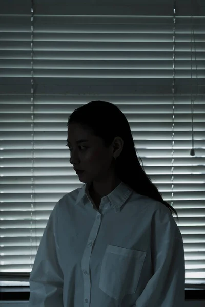 Długie Włosy Kobieta Białych Ubraniach Siedzieć Zamkniętym Oknie Odrobiną Światła — Zdjęcie stockowe