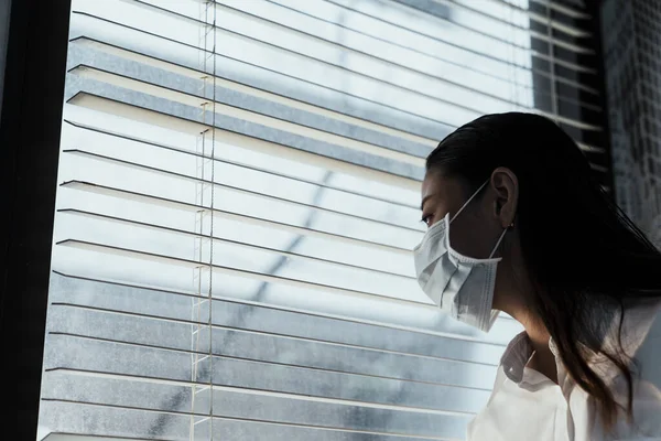 Svart Långt Hår Kvinna Bär Hygienisk Mask Titta Genom Glasfönstret — Stockfoto