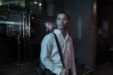 Evine giden yolda binanın önünde duran bir adam..