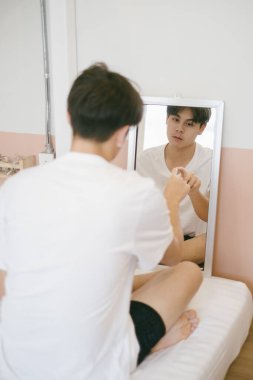 Boş zihinli adam aynanın önünde oturuyor, işaret parmağı aynaya bakıyor ama hiçbir şey ifade etmiyor..