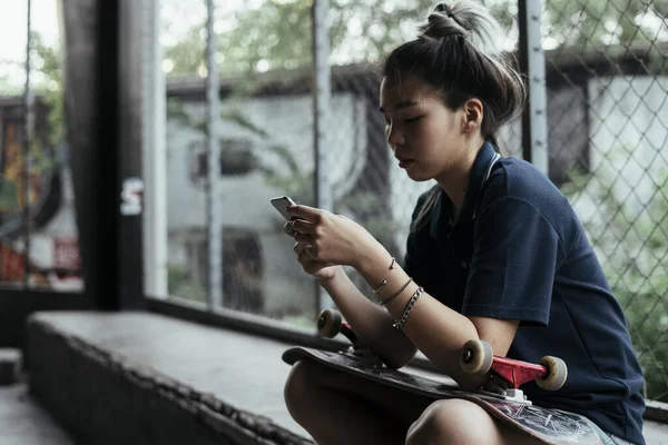 Gördeszkás Lány Használja Mobiltelefon Csevegni Barátjával — Stock Fotó