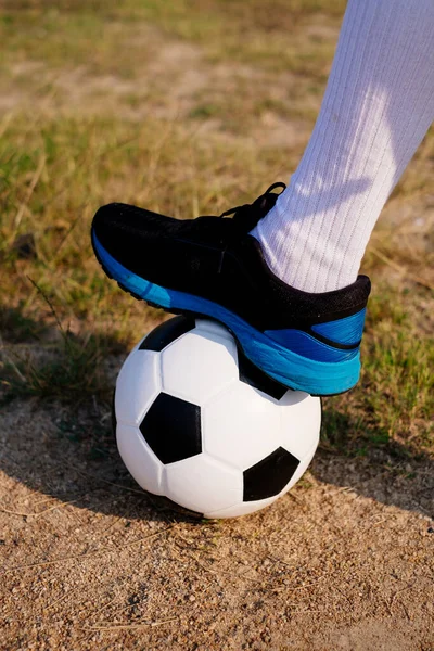 Young Thai football player stop the ball by his foot.