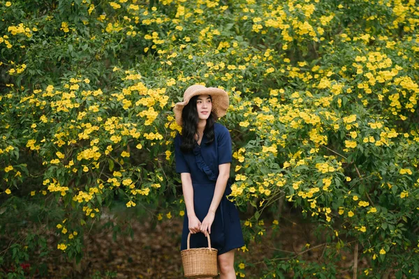 Koyu Mavi Elbiseli Güzel Bir Taylandlı Kız Sarı Çiçeklerin Önünde — Stok fotoğraf