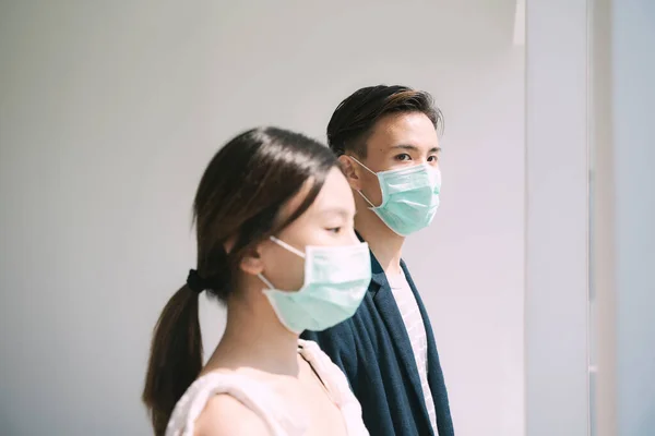 亚洲夫妇的Sideview戴着医生面具呆在屋里 以防止Covid 19从外面出现 人们呆在家里 — 图库照片