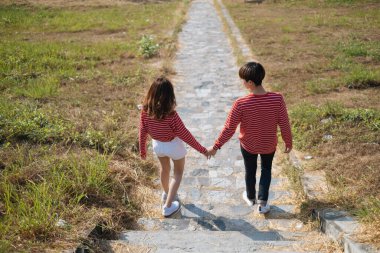 Bir çift el ele tutuşup yamaçtan aşağı iniyor..