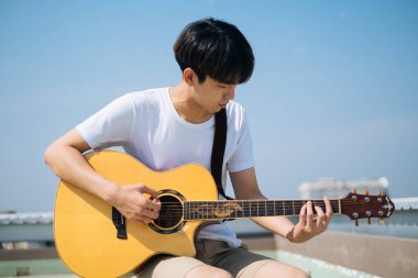 Güneş ışığında gitar çalan adam..