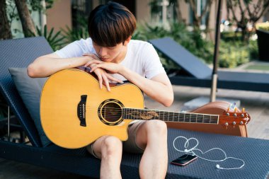 Adam gitar çaldıktan sonra kanepede dinleniyor..