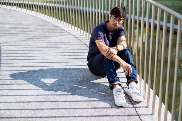 Kanalın yanında tek başına oturan bir adam.