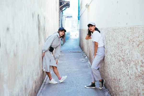 泰国姑娘们像个嬉皮士似的趴在小巷的墙上 — 图库照片