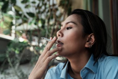 Kafede sigara içen rahat bir kız..