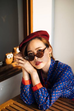 Havalı Taylandlı kız oturuyor ve kameraya bakıyor..