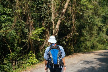 Mavi çantalı adam ormana giriyor..
