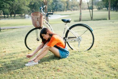 Arkasında bisikletle çim tarlasında oturan tatlı kız..
