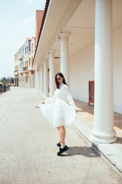 Beyaz elbiseli, beyaz etekli güzel bir kadın..