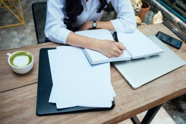 Ahşap masa ve matcha latte üzerinde bir sürü kağıt var..