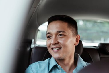 Arabanın arka koltuğunda bir iş adamının gülümsemesini yakından çek..