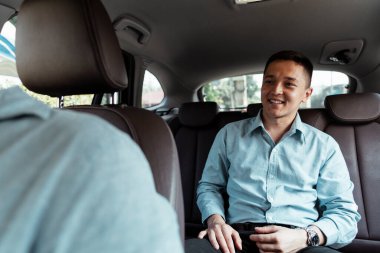 Arabadaki bir iş adamının yüzü kısayol alırken gülümser..