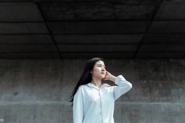 Yazın rüzgarlı havasında, çatı katının önünde duran bir kadın..