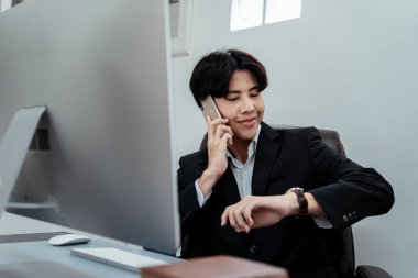Young CEO got a confirming phone from his staff about upcoming appointment. clipart