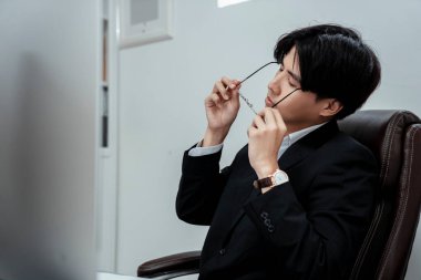 Genç işadamı işini bitirdikten sonra biraz dinlenmek için gözlüklerini çıkardı..