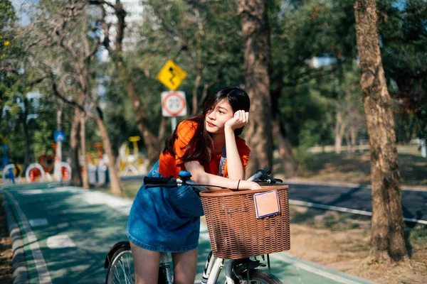 女孩骑自行车在公园里休息 — 图库照片