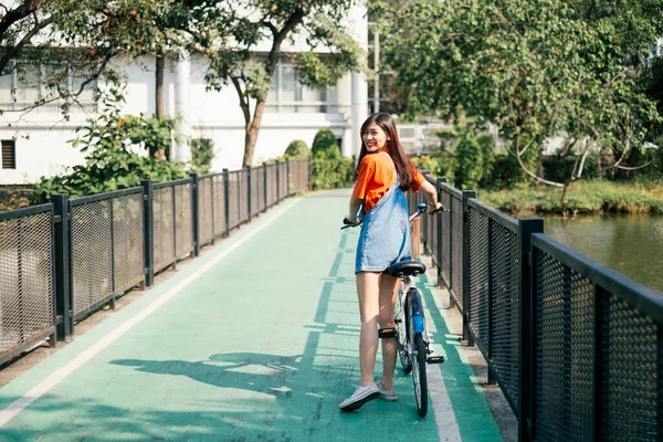 橋の上を自転車で歩く女の子 — ストック写真