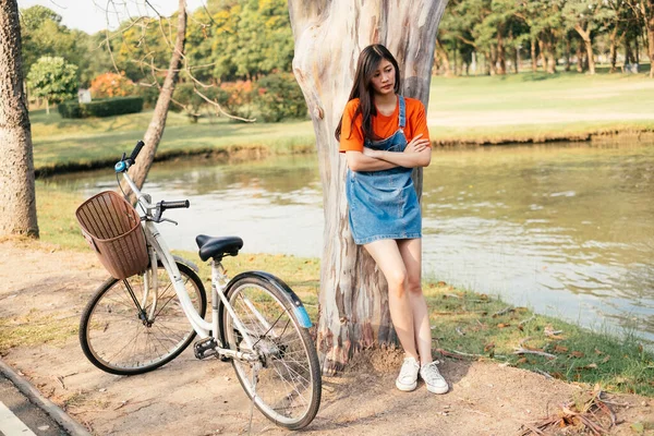 Menina Bonito Encostado Contra Uma Árvore Perto Bicicleta — Fotografia de Stock