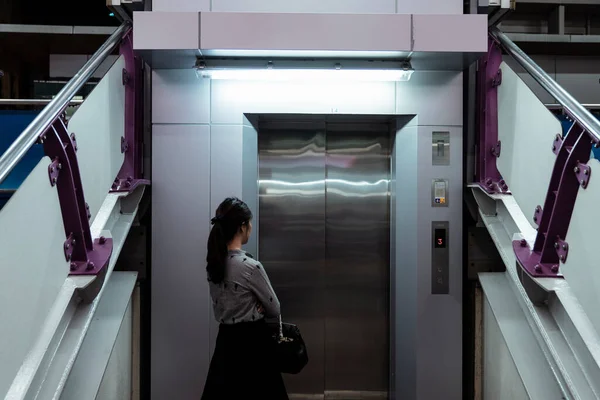 Petugas Wanita Menunggu Infrontof Lift Stasiun Skytrain Malam Hari — Stok Foto