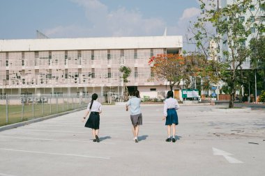 Üç öğrenci binaya doğru ilerliyor..