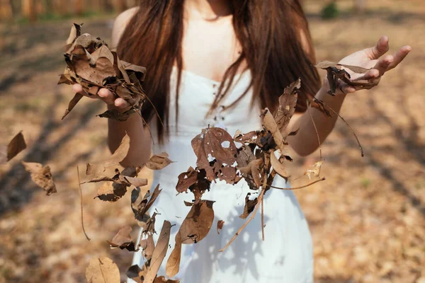 手から乾燥した葉を振りかける女の子 — ストック写真