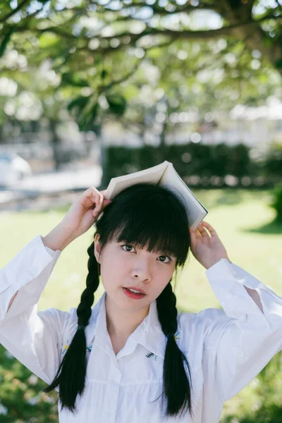 Nettes Mädchen Schuluniform Bedeckt Ihren Kopf Mit Einem Buch — Stockfoto