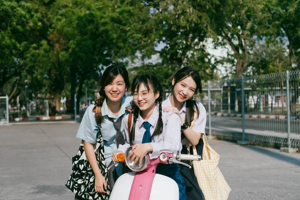 Trzech Studentów Siedzących Różowym Motocyklu — Zdjęcie stockowe