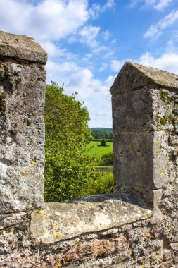 Surlar veya üstünde-e doğru çok güzel yeşil kırsal bir kale duvarı crenellation arıyor.
