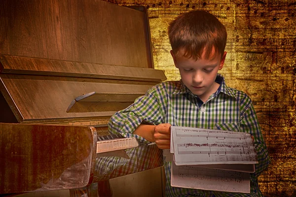 Ritratto di un ragazzo che legge spartiti per pianoforte notazione — Foto Stock