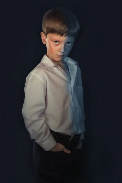 Retrato de um menino em um fundo preto — Fotografia de Stock