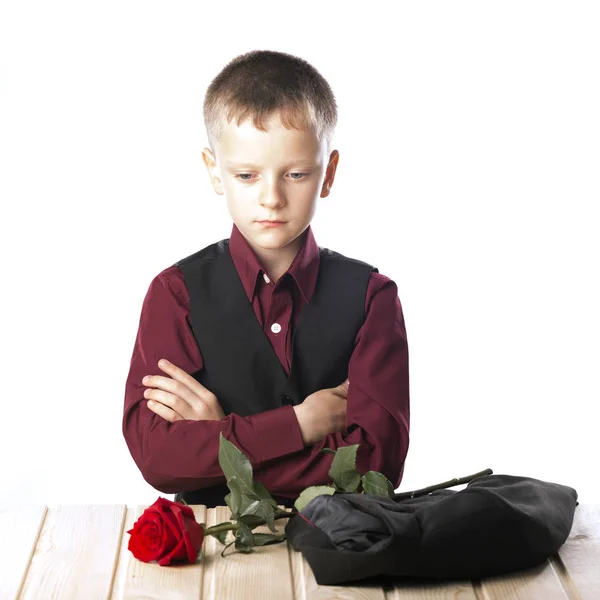 Un joven con una rosa roja. El hombre está sentado a la mesa. . — Foto de Stock