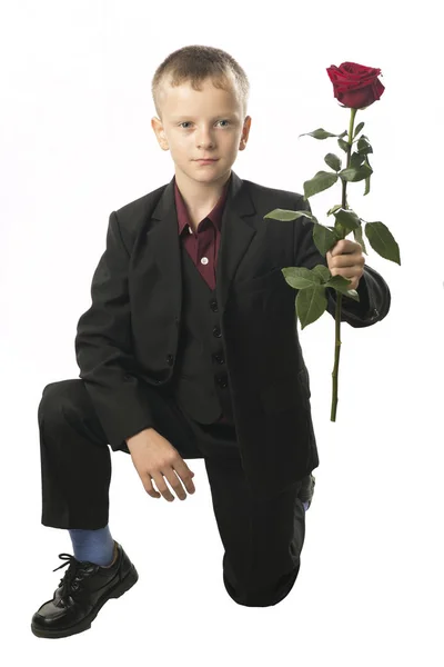 Niño con la rosa roja. Joven figura distinguida en una oscuridad — Foto de Stock