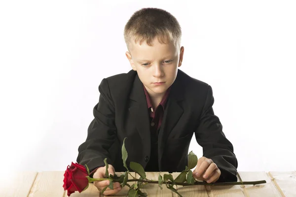 Giovanotto con una rosa rossa. L'uomo è seduto al tavolo . — Foto Stock