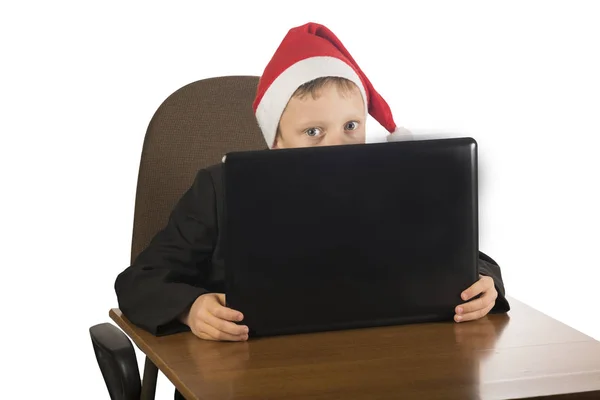 Junge mit Weihnachtsmann-Hut am Computer. — Stockfoto