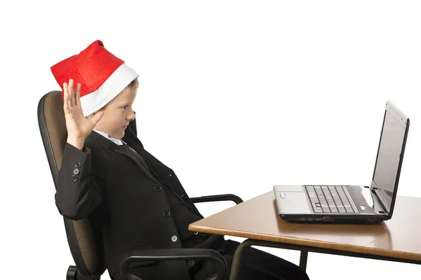 Junge mit Weihnachtsmann-Hut am Computer. — Stockfoto