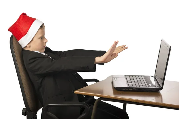 Junge mit Weihnachtsmann-Hut am Computer. — Stockfoto