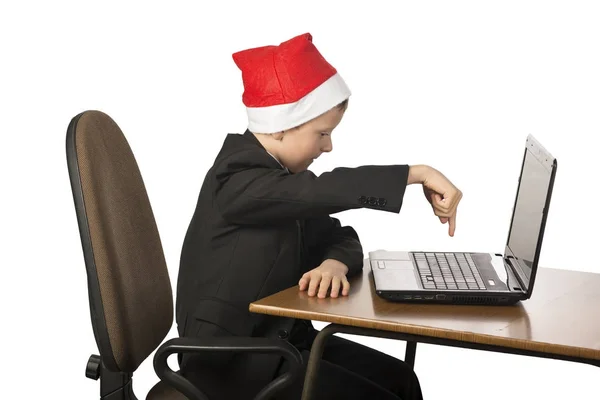 Junge mit Weihnachtsmann-Hut am Computer. — Stockfoto