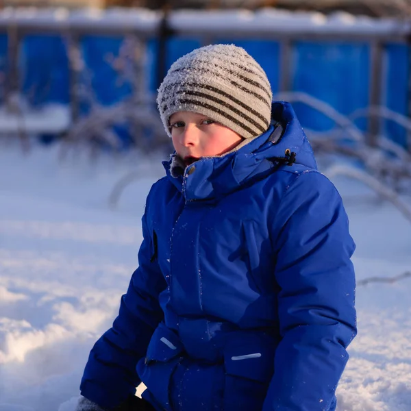 Bambino in abiti invernali fuori città sullo sfondo di un paesaggio invernale innevato . — Foto Stock