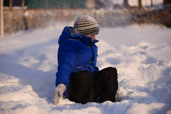 Kind in Winterkleidung außerhalb der Stadt vor dem Hintergrund einer verschneiten Winterlandschaft. — Stockfoto