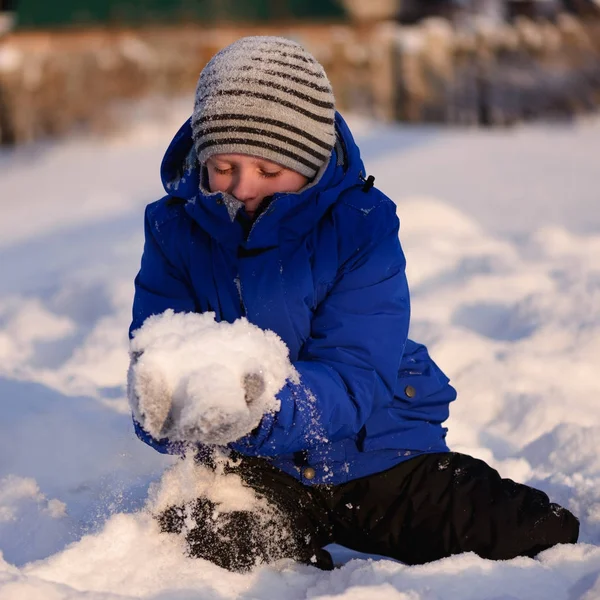 Kind in Winterkleidung außerhalb der Stadt vor dem Hintergrund einer verschneiten Winterlandschaft. — Stockfoto