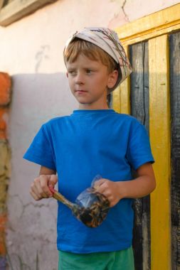 Bir çocuk kapıyı açık hava yaz aylarında açık havada boyama tarafından bir resim yapar. Düzeni tekrar kurmak ve binanın görünümünü iyileştirmek. Fırça boya kavanoza dips.