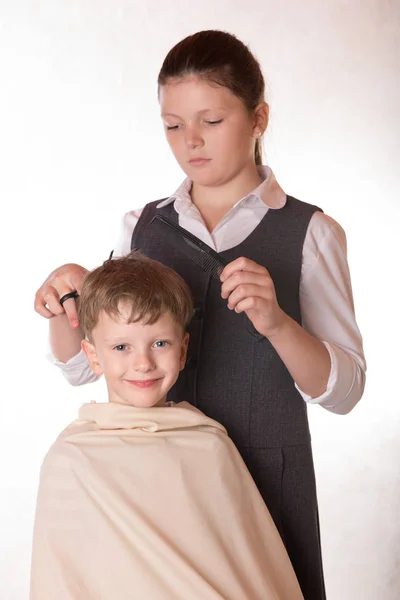 Un ragazzo ad un ricevimento dal barbiere. Un giovane visita il salone o — Foto Stock