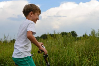 Çocuk bir açık havada güneşli bir günde Bisiklete binmek. CI dışında seyahat