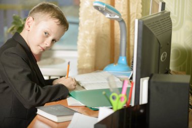 Çocuğa bir kişisel bilgisayarda ofisinde çalışıyor. O bir l yazıyor