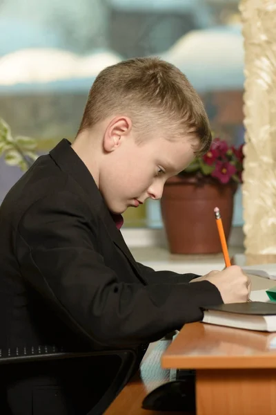 De jongen werkt in zijn kantoor op een personal computer. Hij schrijft een l — Stockfoto